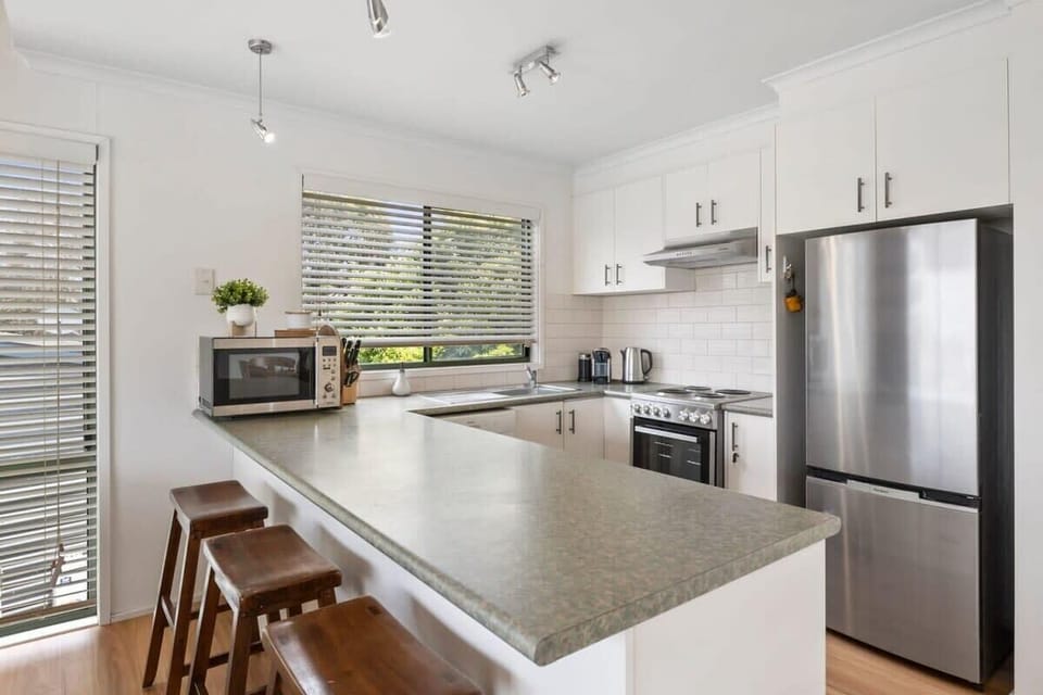 Well-equipped kitchen includes modern appliances, a Nespresso coffee machine, and a breakfast bar for casual dining