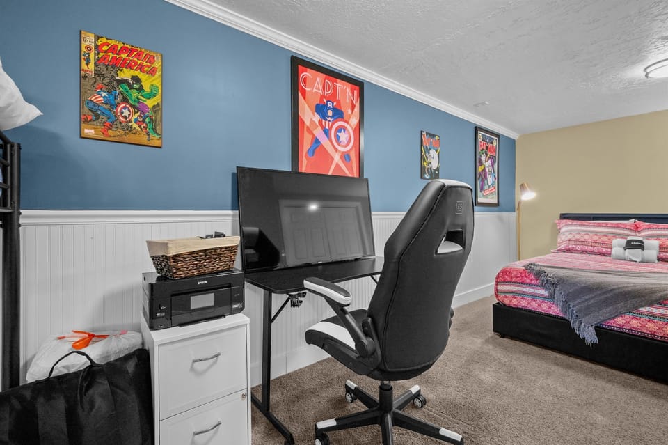 Lower-level bedroom featuring office desk, dresser, and ample closet space.