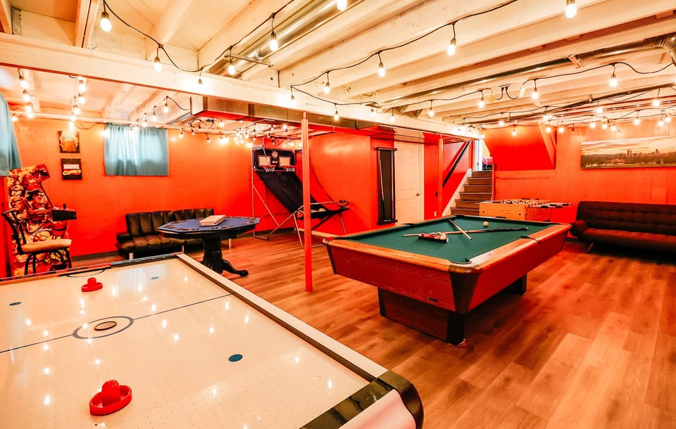 The bold red wall of this game room energizes the space, creating an electrifying backdrop for epic battles and laughter-filled evenings.