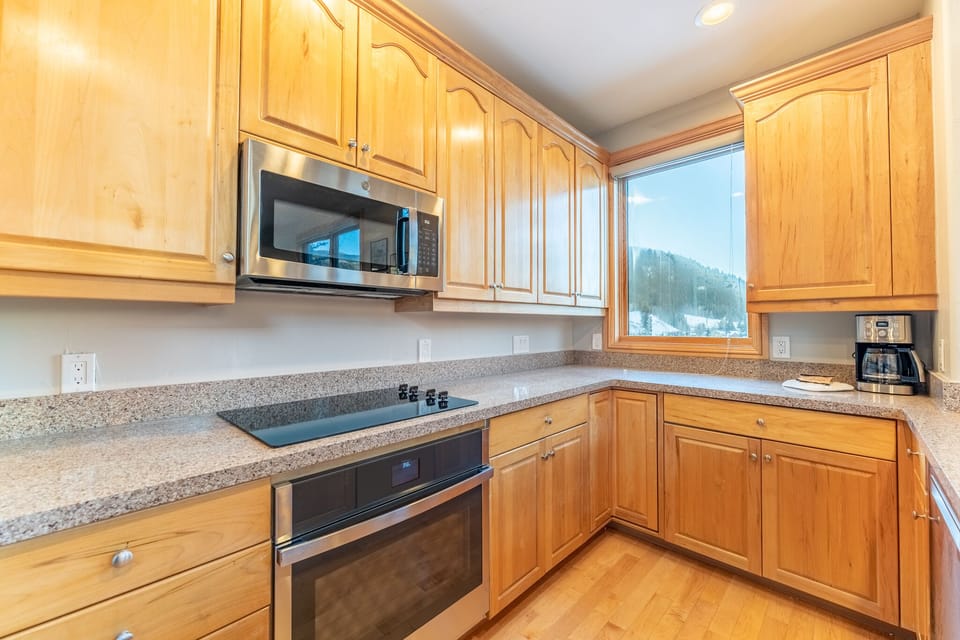 Cook your favorite meals in this fully equipped kitchen while enjoying stunning mountain views through the large window.
