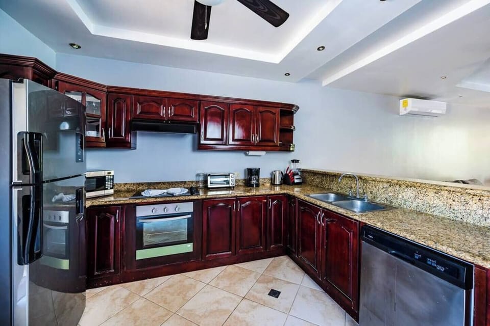 Fully equipped kitchen at Guapinol condo in Langosta Beach, Tamarindo—features modern appliances, full-size fridge, stove, microwave, and ample counter space, perfect for preparing meals after a day at Playa Tamarindo or nearby adventures.