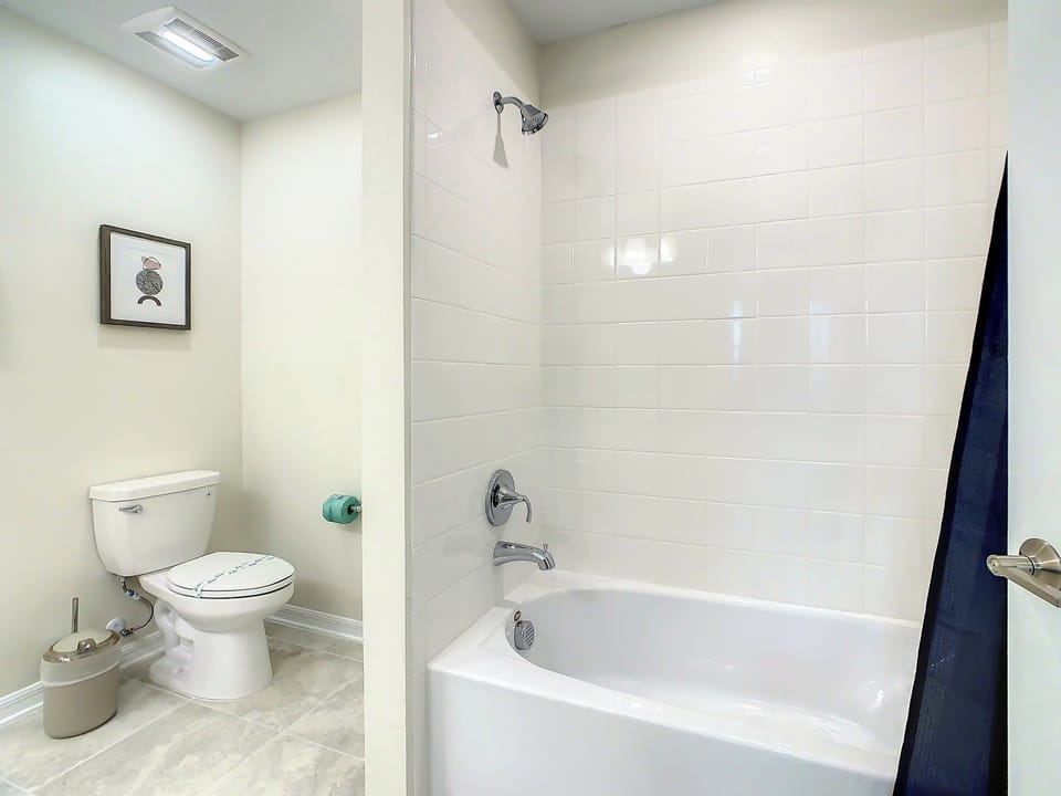 Bright Full Bathroom with Tiled Bathtub and Shower