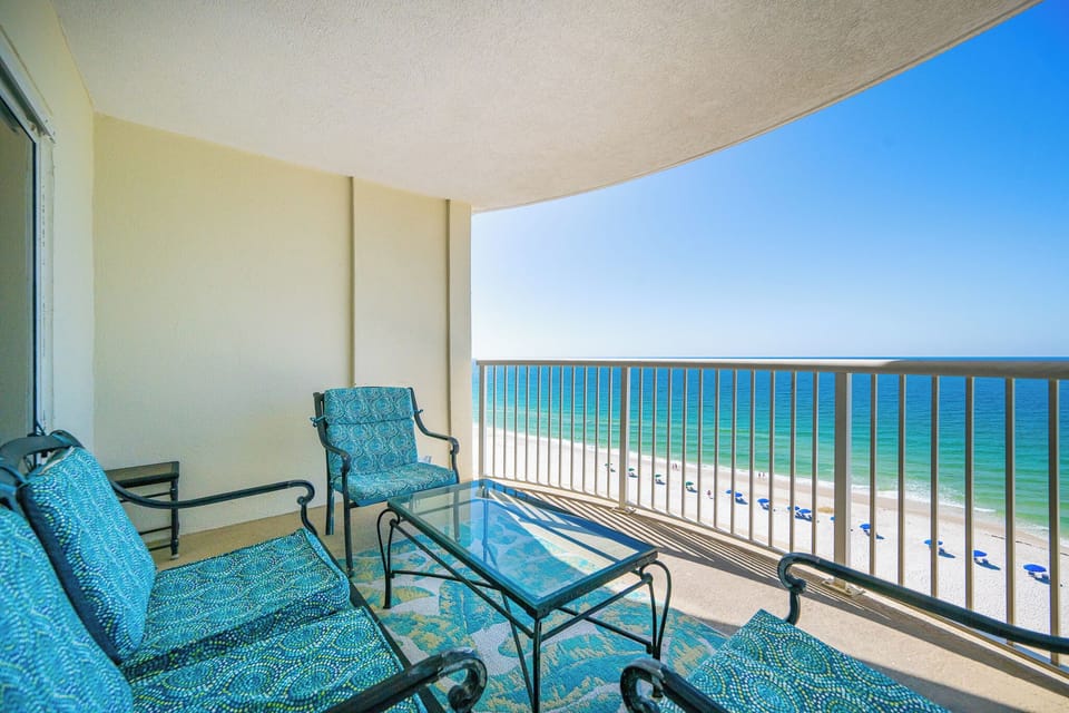 This balcony offers a serene beachfront view, featuring comfortable seating and a relaxing atmosphere