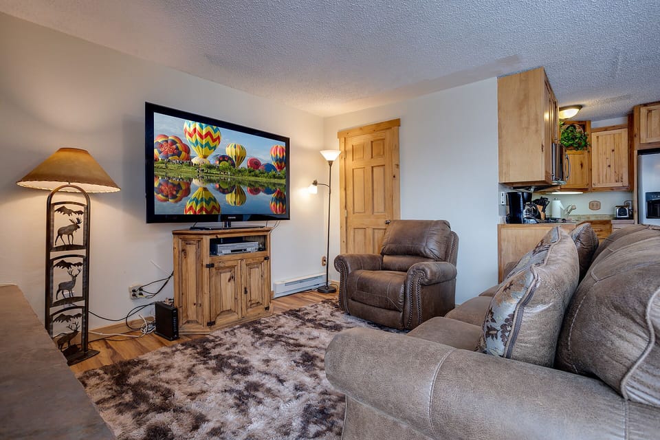 Sink into plush leather seating while your favorite shows play on the wall-mounted TV in this cozy mountain-themed living space.