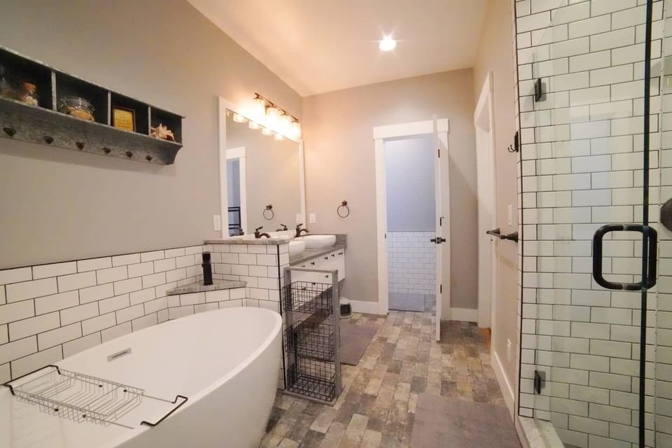 The en suite bathroom features a soaking tub, walk-in shower, and a double vanity.
