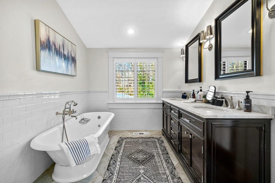 This stunning en suite bathroom features a double sink, soaking tub and tiled shower.