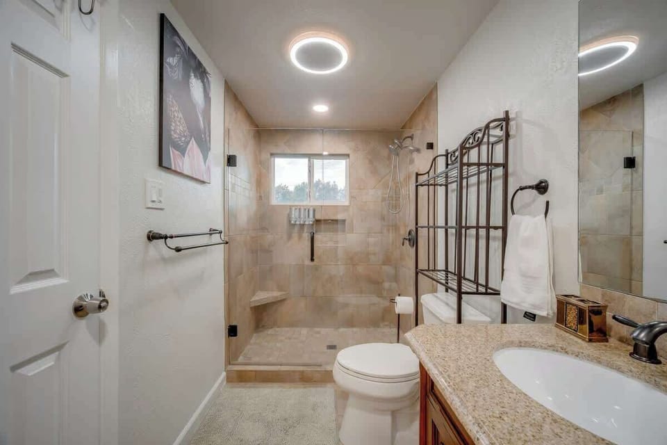 A bright, modern bathroom with a sleek glass walk-in shower and a clean, spa-like feel.