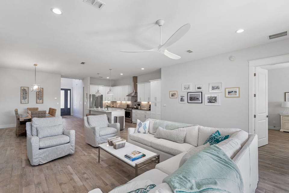 Spacious, light-filled living room with oversized seating and open flow into the kitchen and dining areas.