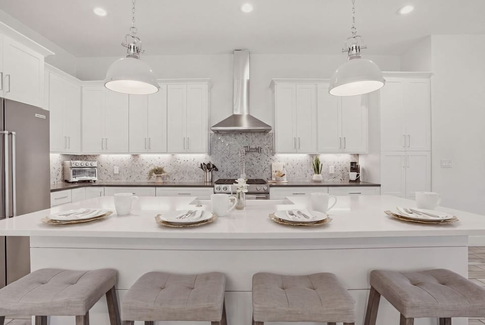 Bright chef’s kitchen with oversized island, modern finishes, and plenty of space for cooking and gathering.
