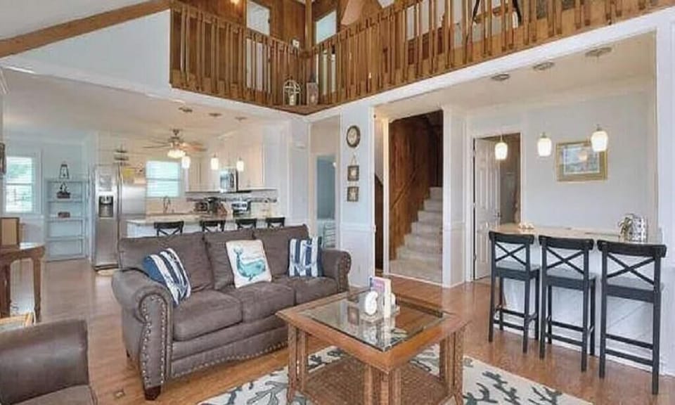 Spacious and open family area with 2 couches, a wet bar, and open to kitchen