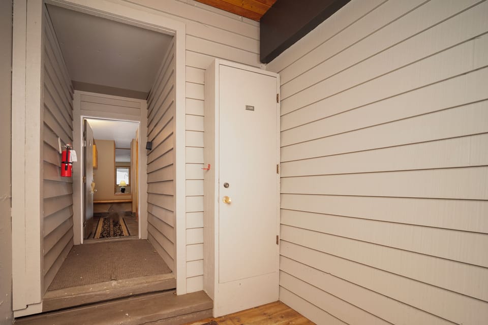 Step through your private entrance into a welcoming space with charming white wood siding and warm wood ceiling beams overhead.