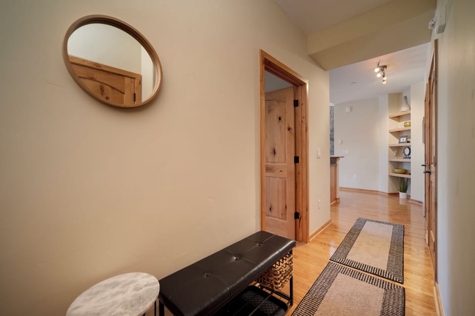 Step into your welcoming entryway where warm wood tones and thoughtful touches like a cozy bench create the perfect arrival experience.