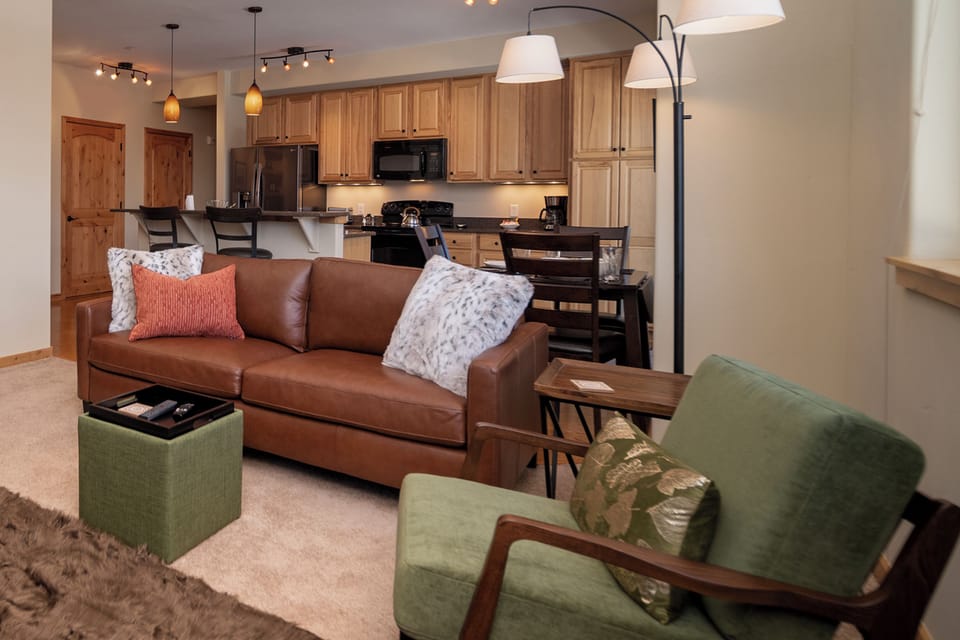 Unwind in your spacious open-plan living area with plush leather sofa and fully equipped kitchen, perfect for memorable evenings together.
