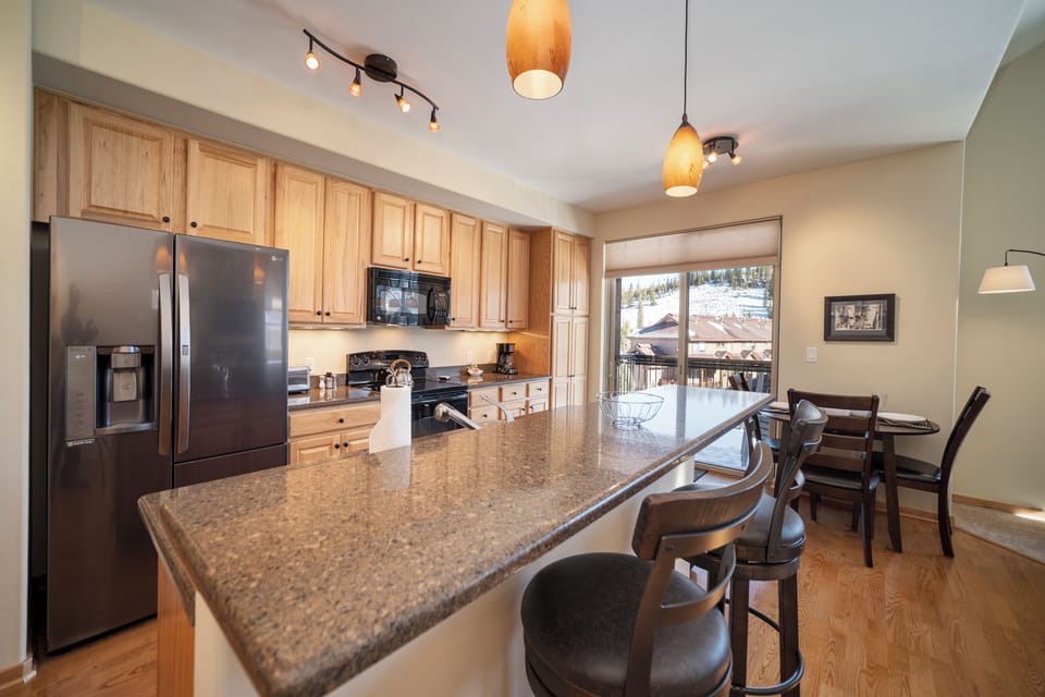 Your spacious kitchen features granite countertops, stainless steel appliances, and a breakfast bar where you can enjoy morning coffee while taking in mountain views.