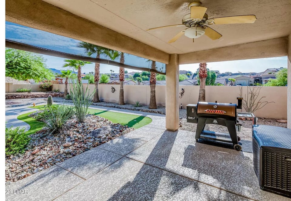 Large patio with fans, shades and a high end barbecue.