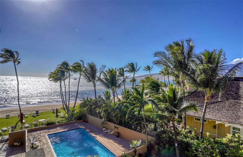  The  condo's lanai has views of the ocean, pool, and mountains. 