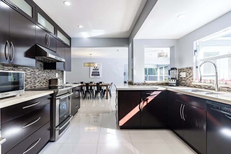 "Enjoy cooking in this modern kitchen with stainless steel appliances, mosaic backsplash, and natural light—perfect for long stays, family meals, and vacation rental comfort!"