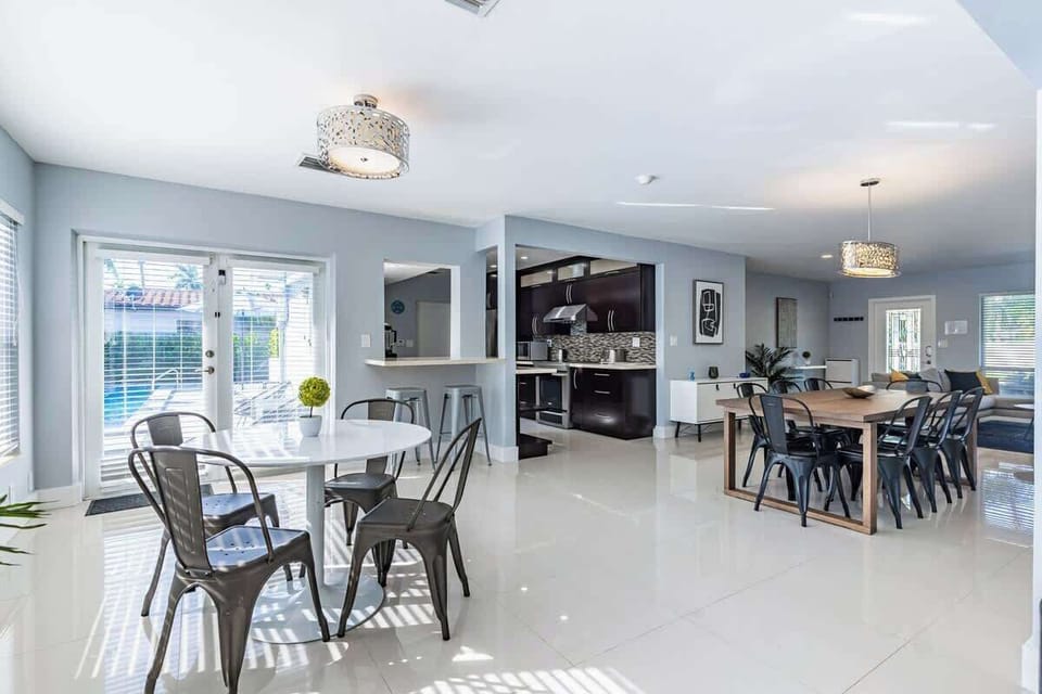 "Cook, dine, and unwind in this stylish open kitchen and dining space—perfect for family meals, group gatherings, and remote work. Your spacious vacation rental with pool access and natural light is ready to welcome you!"