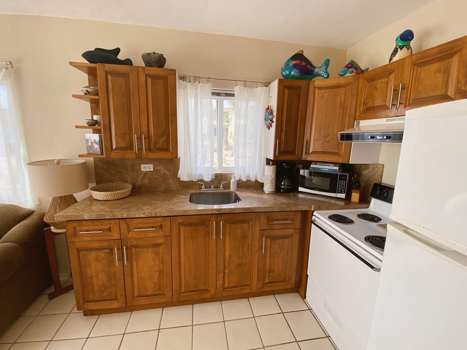 Fully equipped kitchen with microwave, toaster, blender, coffeemaker, and more.