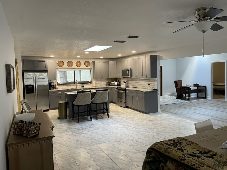 kitchen opens up to main living area. Desk & sofa at one end, Family rm on other