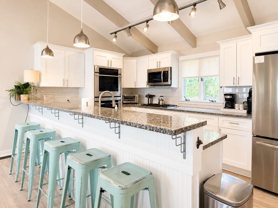 Modern farmhouse kitchen with mint stools