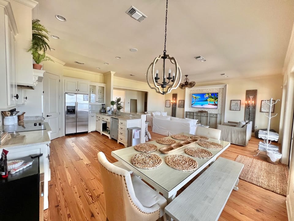 Well appointed kitchen, table & bar overlooking a balcony with sunset views. 