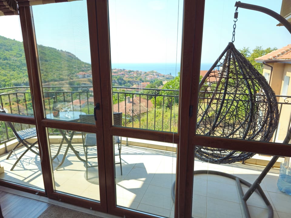 Terrace with sea view, egg chair and table and 2 chairs
