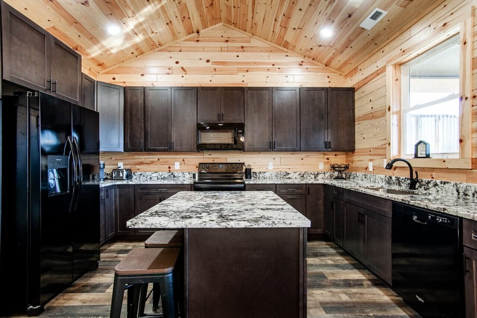 Fully equipped modern kitchen with granite island and sleek design.