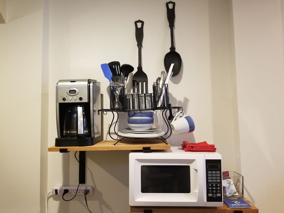 View of coffee maker, microwave and dishes & utensils