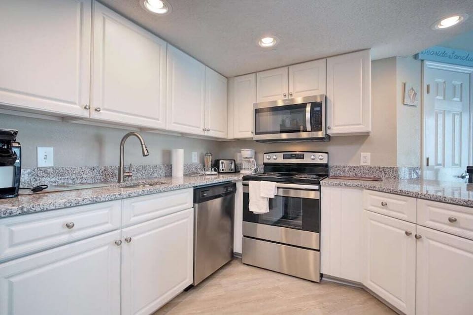 Kitchen: Bright white cabinetry and sleek stainless steel appliances await your culinary adventures!