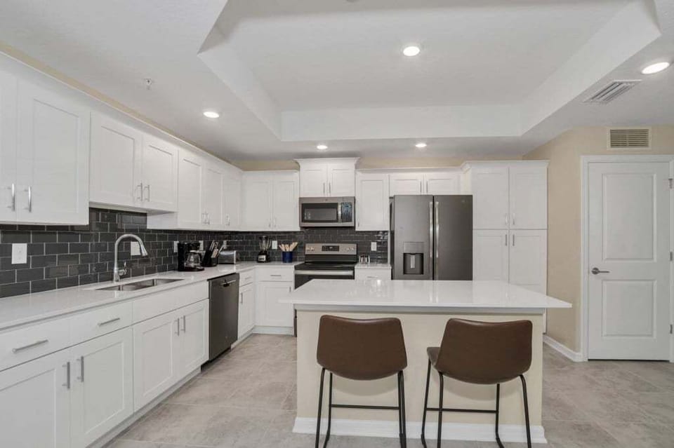 The kitchen features stainless steel appliances, granite counter tops and seating for 4 at the kitchen island.