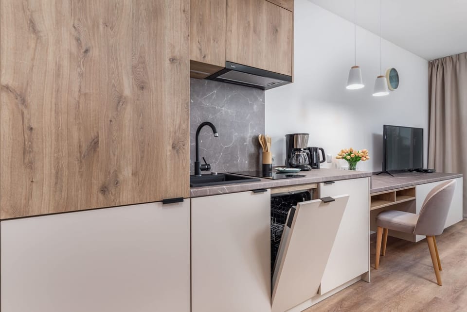 A modern kitchen with wood-accented cabinets, sleek appliances, and ample counter space.
