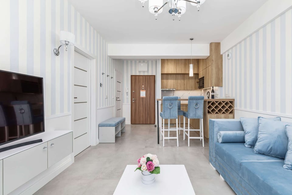 A view of the dining area with light blue chairs and a wooden dining table, adjacent to the kitchen.