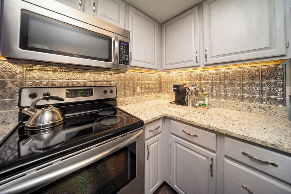Your fully equipped kitchen features granite counters, decorative backsplash, and modern appliances for comfortable home cooking.
