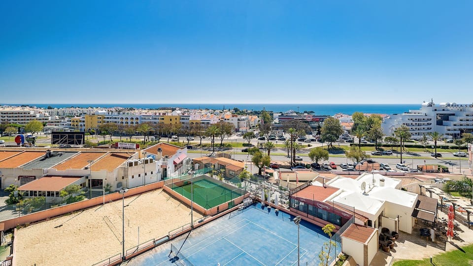 Enjoy expansive vistas over the lively town, with the sparkling sea in the distance and active sports courts below.
#SeaView #SportsCourts #LovelyStay