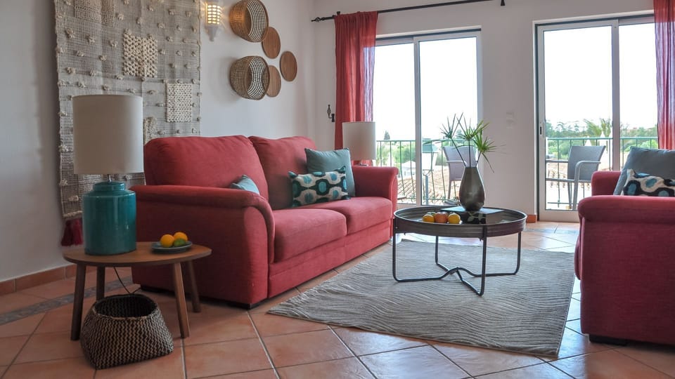 The light and airy living room features a comfortable seating area as well as a dining area with space for up to 6 people