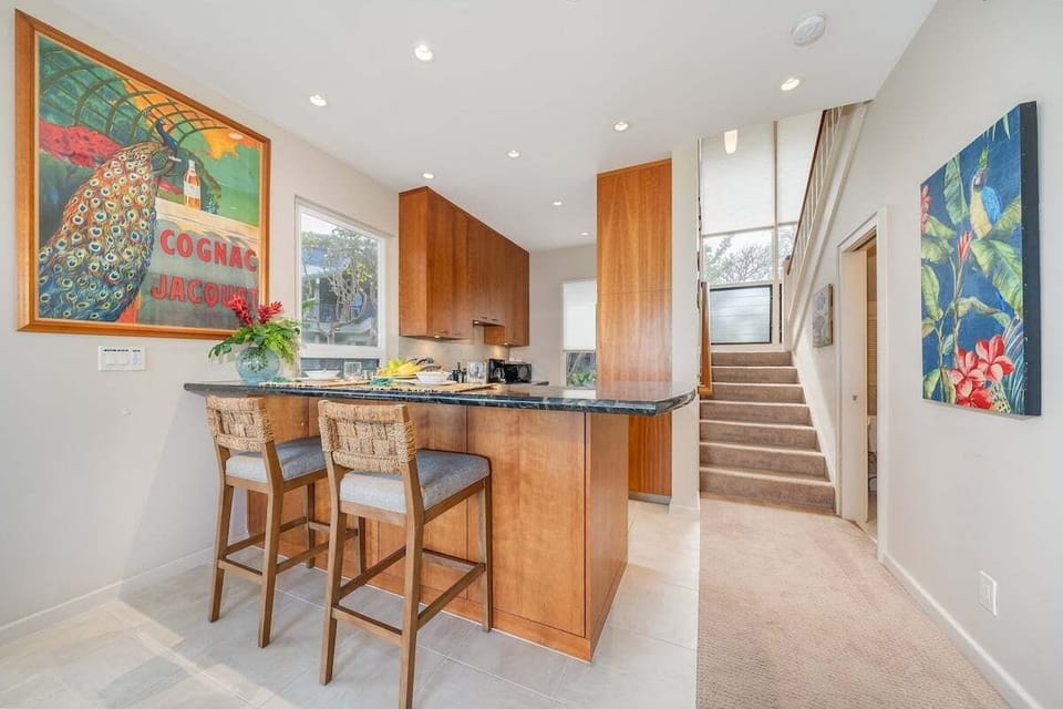 Savor meals at a cozy breakfast bar in a bright kitchen with elegant finishes.