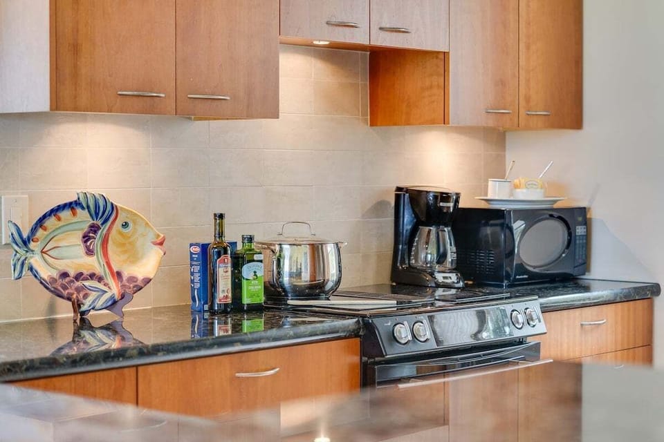 Cook in a stylish kitchen with granite counters and stainless steel appliances.
