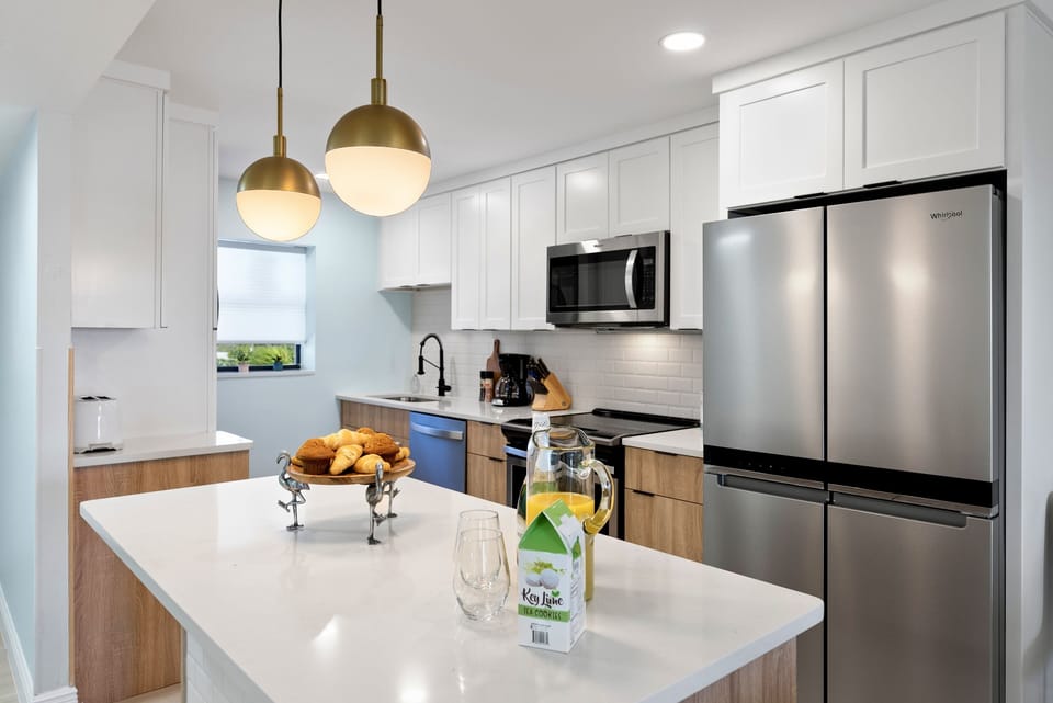 Sleek kitchen with stainless steel appliances, a spacious island, and modern lighting.