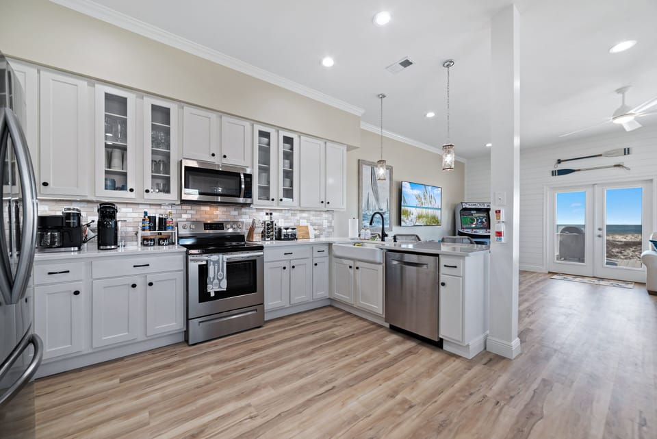 A newly renovated, fully stocked kitchen featuring an expansive coffee bar and sleek stainless-steel appliances - where cooking enthusiasts and coffee lovers will enjoy