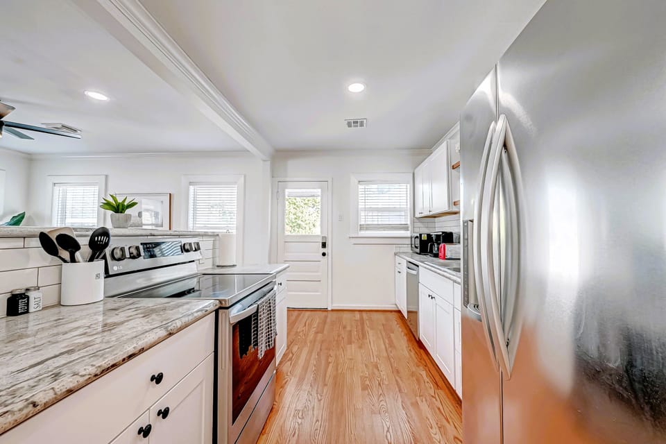 Full kitchen with view of door to back balcony. 