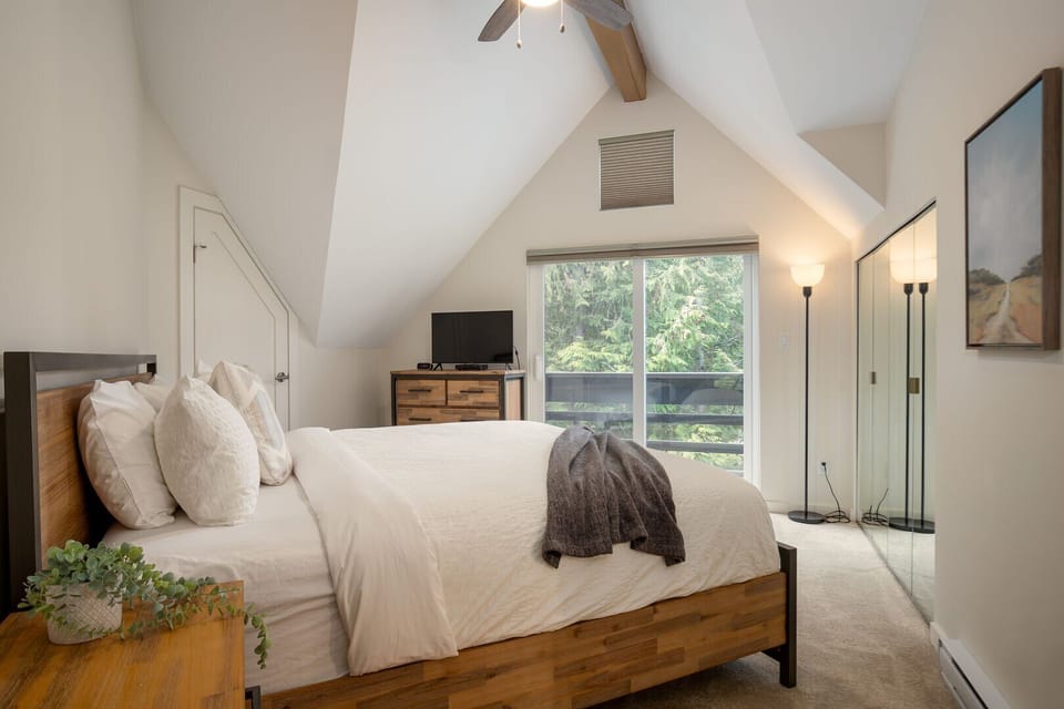 A peaceful upstairs retreat with a king bed, forest views, and spa-like ensuite with jetted tub.