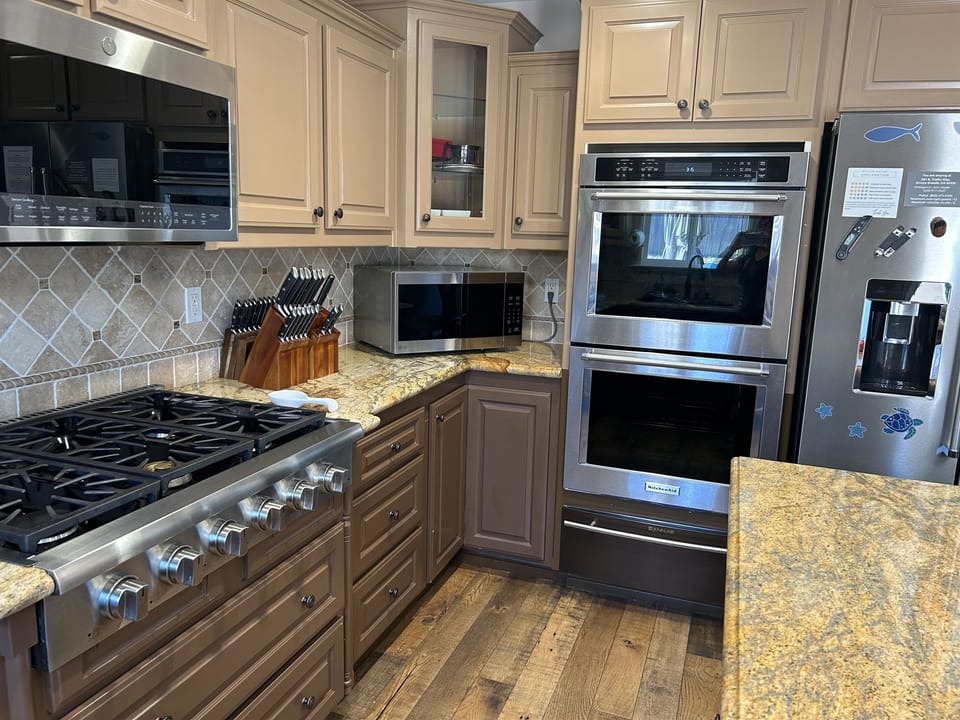 Double ovens (one convection),  6 burner stovetop, 2 microwaves 