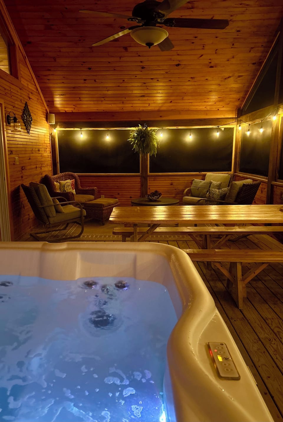 Screened porch at night with string lights on