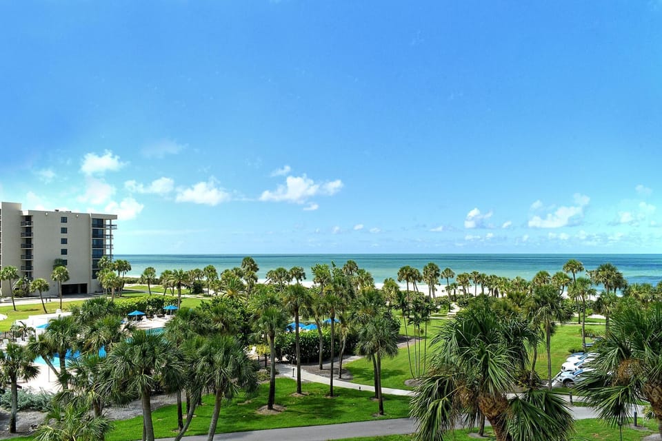 Oceanfront view with lush greenery and sunny skies