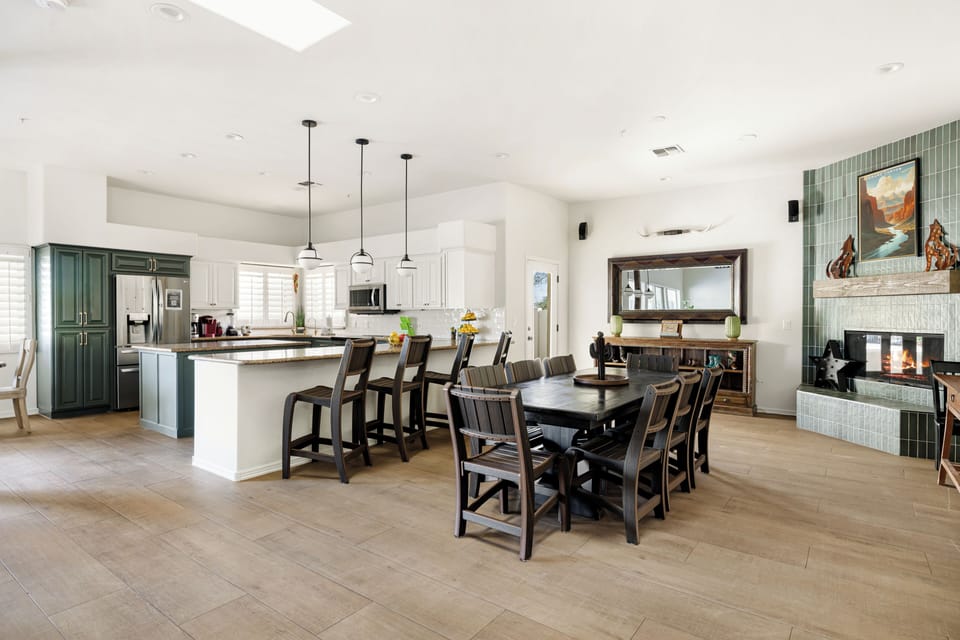 Spacious dining area with seating for the whole group, a breakfast bar, and a cozy fireplace centerpiece.