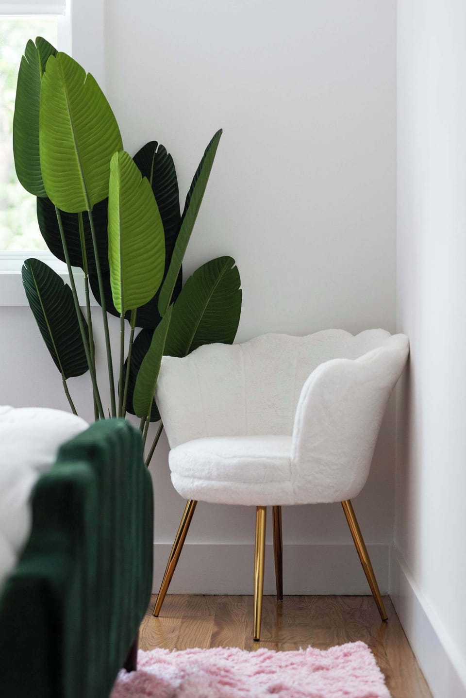 A peaceful spot to relax, complete with a chic white chair and plant accents.