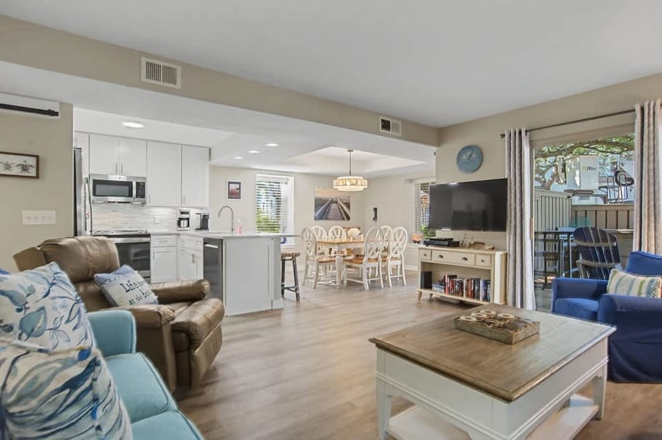 Relax in your open-concept haven where coastal blues meet warm neutrals, creating the perfect flow from kitchen to living space.