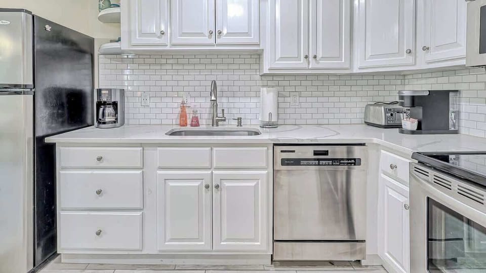modern kitchen with stainless steel appliances and white cabinetry