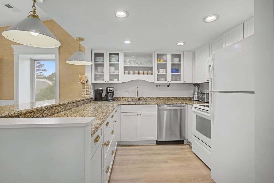 You'll love preparing meals in this bright, fully-equipped kitchen with granite countertops, stainless appliances, and pendant lighting.